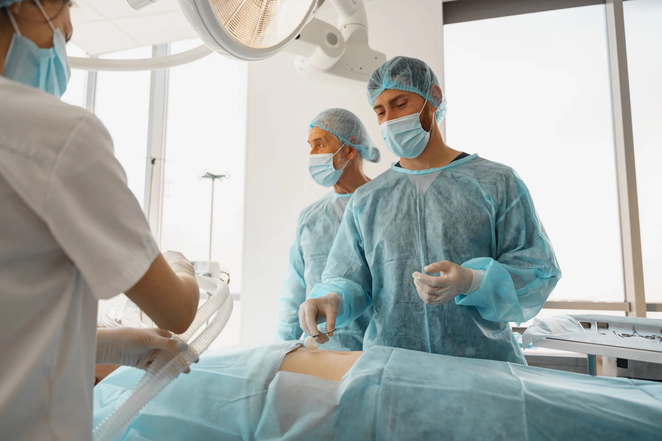 Chirurgisches Team in steriler Kleidung bereitet sich auf eine Operation vor.