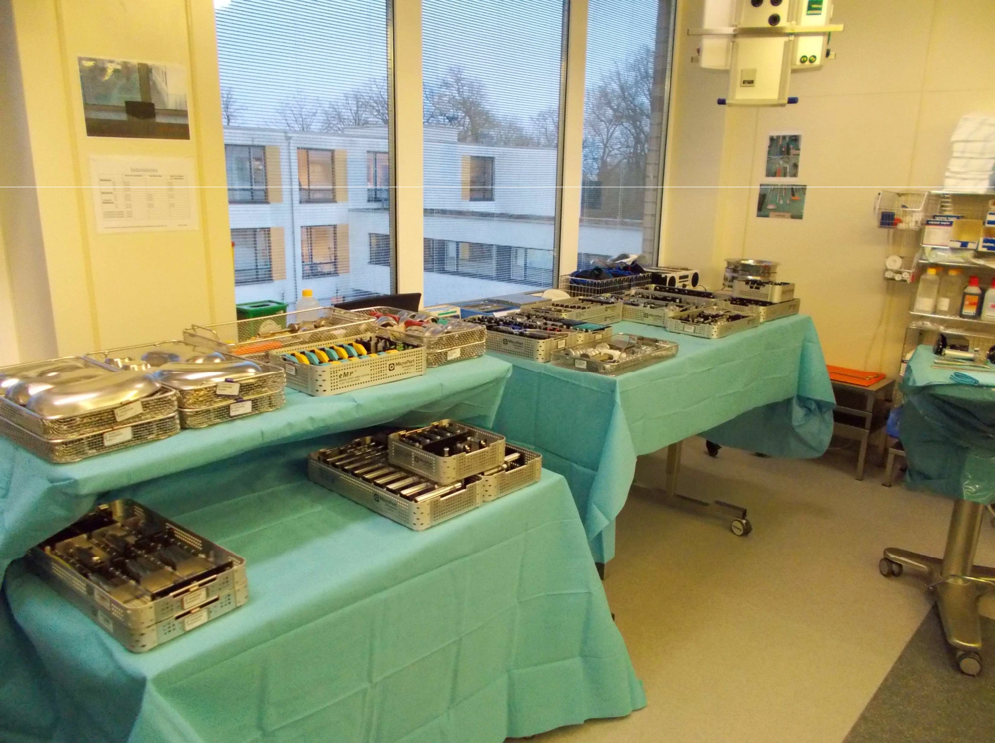 Mehrere mit medizinischen Instrumenten bestückte Tische in einem Operationsraum.